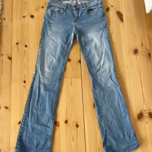 Blå bootcut jeans från Zara Woman - Säljer ett par klassiska blå bootcut lågmidjade jeans från Zara Woman. Jeansen har fem fickor, normal passform och stängs med dragkedja och knapp. Skulle säga att de passar S men det står i lappen att de är storlek 38