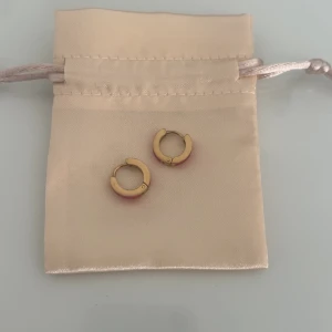 Guld- och rosa örhängen från Edblad  - Säljer ett par stilrena guldörhängen med en rosa detalj. Perfekta för att ge en färgklick till din outfit. Kommer i en elegant förvaringspåse! Och dessa är ifrån Edblad och är slutsålda på deras hemsida! Kostade 349:- nya dessa är aldrig använda heller då jag känner att de inte passar mig tyvärr 