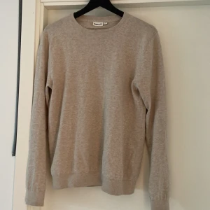 Beige stickad tröja från Kappahl - Säljer en stilren beige stickad tröja från Kappahl i storlek S. Tröjan har rund halsringning, långa ärmar och ribbade muddar vid ärmslut och nederkant. Perfekt för lager-på-lager och enkel att matcha med olika outfits.