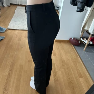 Svarta kostymbyxor från bikbok 2st 36 och 38 - Säljer ett par klassiska svarta kostymbyxor med normal passform och hög midja. Byxorna har raka ben, bälteshällor och diskreta fickor fram och bak. Perfekta till en stilren look och passar till många olika tillfällen. Har ett par i 36 och ett par i 38. Aldrig använda. Skriv vilken storlek ni vill ha 