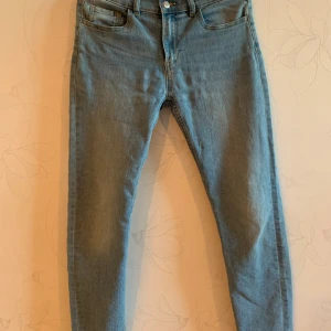 Blå jeansbyxor från Stephan - Säljer ett par klassiska blå jeansbyxor från Stephan. De har en normal passform med fem fickor och en dragkedja med knapp framtill. Perfekta för en avslappnad stil. Det går att justera storleken på jeansen genom knappar inom jeansen (bild två). Kontakta mig gärna om du vill veta mer eller vill diskutera priset!