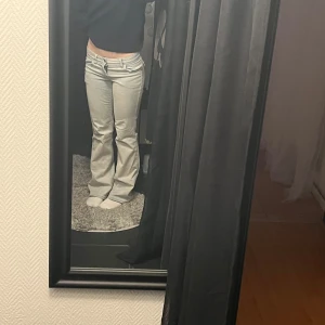 bootcut jeans med låg midja - Säljer ett par jeans med bootcut och låg midja samt knappfickor på baksidan! Köpta i somras men knappt använda och har därför inga stora defekter! Färgen är typ lite créme vits aktig. Skriv för fler detaljer eller bilder💓😇