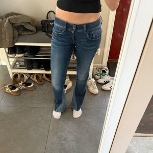 Blå bootcut jeans - Blåa bootcut jeans och bootcuten är sydd på egen hand med ett annat jeans tyg. Skit snygga fickor med dragkedjor och dom är lågmidjade. Dom är från G-STAR RAW DENIM. Size 27 och Length 32.