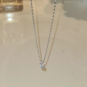 Silverfärgat halsband med klar sten - Ett stilrent halsband i silverfärg med en tunn kedja och en rund, klar sten som hänge. Perfekt för dig som gillar minimalistiska smycken med en touch av elegans.💕