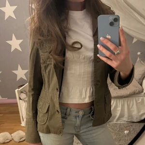 Jeansjacka  - En jeansjacka med en grön/brun nyans 💞Från Lindex med fyra stora fickor framtill och knappar. Jackan har klassisk krage och markerad midja för en snygg passform. 