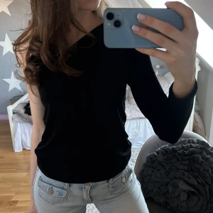 Svart oneshoulder topp från Gina Tricot - Snygg svart oneshoulder topp från Gina Tricot 💞Toppen har en lång ärm och är figurnära med stilren design. Perfekt för att skapa en trendig look.