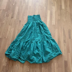 Mönstard långkjol från Zara - Långkjol i mjuk bomull med grönt geometriskt mönster. Kjolen har bred smock i midjan för en bekväm passform och ett luftigt, voluminöst fall. Perfekt för dig som gillar färg och mönster. Ett litet hål finns men som går att sy men har inte haft möjlighet till det