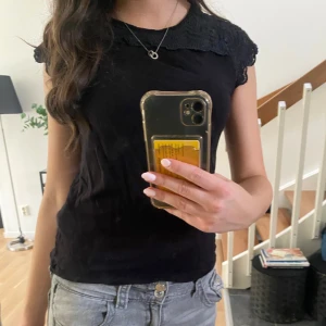 Svart spetstopp - Svart topp från Lindex i storlek S med fina spetsdetaljer vid kragen och ärmsluten. Modellen är ärmlös med en klassisk rund halsringning💕Perfekt till alla tillfällen!