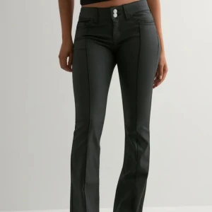 Low Waist Bootcut coated jeans  - Nya oanvända jeans från Nelly. Med prislapp kvar, säljer pga att de ej passar. Storlek 34, Ordpris 699kr