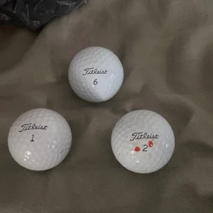 Titleist Pro V1 Golfbollar - 3 st Titleist Pro V1 golfbollar i bra skick. Några mindre märken och en boll har röda markeringar. Perfekt för dig som vill ha tourkvalitet till ett bra pris. Modeller: Pro V1 och Pro V1 392. Se bilder för detaljerat skick.