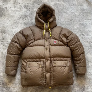 Fjällräven expedition down lite jacket - Brun fjällräven expedition down lite jacket i fint skick. Har en liten fläck (bild 2) som knappt syns. Storlek xxs men väldigt stor i storleken så passar snarare som en small. Skriv vid eventuella frågor 😌