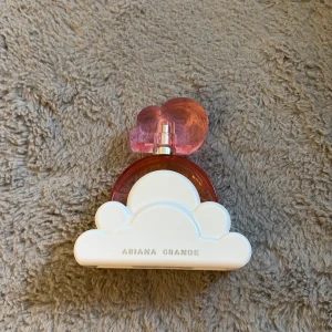Ariana Grande Cloud Pink - Snygg parfym från Ariana Grande med unik design. Perfekt för dig som vill ha en trendig accessoar på sminkbordet. Flaskan har en cool molnformad detalj och passar dig som gillar popkultur och stil.