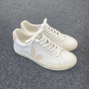 Vita Veja sneakers  - Snygga vita sneakers från Veja med beige mockadetaljer på häl och sidor. Köpta för 1660, använt endast 1 gång så är i väldigt fint skick