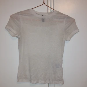 Vit basic t-shirt från H&M, XXS - Enkel och stilren vit t-shirt från H&M i storlek XXS. Materialet är mjukt och känns skönt mot huden. Genomskinlig. Använd kanske 2 gånger så nästintill nyskick!!!