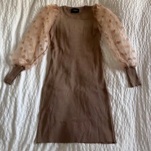 Fin klänning - Jättesöt klänning med genombrutna och prickiga armar. Tyget är stretchigt. Har aldrig använts!