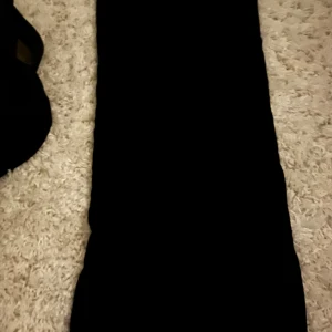 Svart ribbad långklänning XS - Svart långklänning från Black Line Collection i storlek XS. Klänningen är ribbstickad och har en tight passform som framhäver siluetten. Perfekt för dig som gillar en stilren och enkel look med en touch av edge.