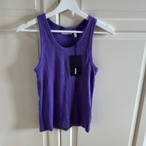 Lila ribbad linnetopp från Weekday - Säljer en snygg lila ribbad linnetopp från Weekday. Toppen är ärmlös med rund halsringning och har en tight passform. Storlek M. Helt ny och etiketten sitter kvar. 