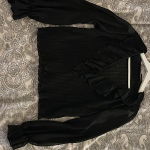 Svart volangblus från Zara  - svart blus från Zara i storlek XS. 