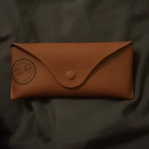 Ray-Ban hexagonala solglasögon guld - Snygga Ray-Ban solglasögon med hexagonala svarta glas och tunn guldfärgad metallbåge. Kommer med klassiskt brunt fodral i skinnimitation. Perfekt accessoar för att lyfta din stil. Priset går att diskutera 