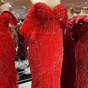 Röd glittrig långklänning offshoulder - Säljer en röd långklänning med glittriga paljetter och pärlor, offshoulder-modell med figurnära passform och släp. Klänningen har en lyxig känsla och är perfekt för bal eller fest. Detaljerad och skimrande design som verkligen sticker ut. Använd endast enstaka timmar. Special sydd för 11.000kr. Säljer för 6999kr