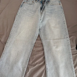 Levi's 501 ljusblå jeans W29 L30 - Klassiska Levi's 501 jeans i ljusblå tvätt med raka ben och normal passform. Jeansen har fem fickor, knappgylf och ikonisk läderpatch bak. Tillverkade i slitstarkt bomullsjeans som ger en tidlös look. Perfekta för dig som gillar vintagevibbar och enkel stil💗