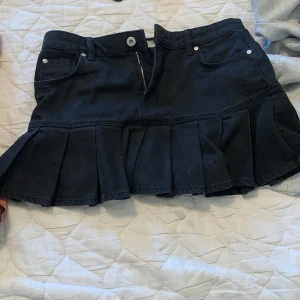 Svart low waisted jeanskjol med volanger - Säljer en svart jeanskjol med bred volang. Säljer den då jag köpt för stor strolek och inte kan lämna tillbaka. Har bara använt den när jag testa kjolen💕