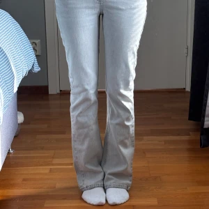 Grå bootcut jeans Gina Tricot 164 - Snygga ljusgrå jeans från Gina Tricot x Izaandelle i storlek 164. Modellen har bootcut-ben, klassiska fem fickor och dragkedja med knapp. Jeansen är i mjuk bomull med en skön passform och passar perfekt till en trendig vardagslook. Låg/mellanhög midja. Passar xs 