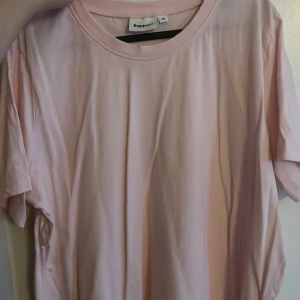 Ljusrosa t-shirt från Kappahl XL - Enkel och stilren ljusrosa t-shirt från Kappahl i storlek XL. T-shirten har rund halsringning och korta ärmar. Oanvänd!