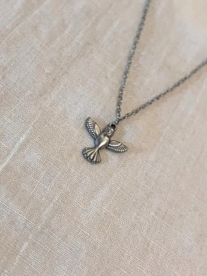 The Silver Dove - Minimalistiskt halsband med en liten duva i högkvalitativt rostfritt stål. Kedja 50 cm, hänge 1,6 × 1,6 cm.