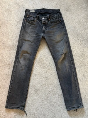 Gråa levis 501 jeans - Snygga svarta/gråa levis 501 jeans i snygg vintage wash. Mycket snygga slitningar och lagningar. 