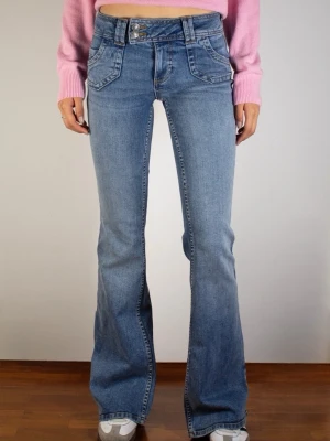 Blå bootcut jeans med dubbla knappar - Snygga blå bootcut jeans med dubbla knappar i midjan och framfickor med lock. Jeansen har en klassisk femficksdesign och är tillverkade i mjukt denimtyg. Perfekta för en trendig och avslappnad look. Nypris 790kr. Skriv för fler bilder!