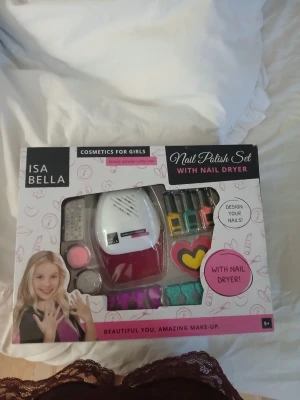 Nagellackset med tork från Isabella - Nagellackset från Isabella med flera färgglada nagellack, glitter, dekorationer och en elektrisk nageltork. Perfekt för att skapa kreativa och färgglada nageldesigner hemma. Innehåller även små burkar med glitter och nageldekorationer i olika former.
