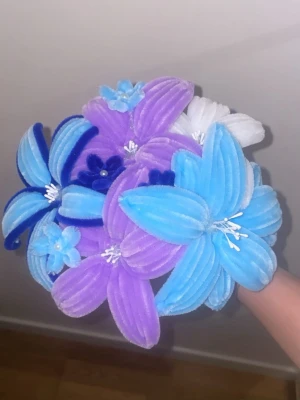 Bukett med piprensarblommor - En färgglad bukett med handgjorda blommor av piprensare i blått, lila och vitt. Blommorna har tydliga kronblad och vita ståndare, perfekt som dekoration eller present. Kreativ och unik detalj till rummet. Kan göras i fler färger och priser varieras på antal rosor, om du vill göra en personlig beställning kontakta mig!