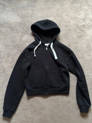 Svart hoodie från Gina tricot 14+ - Säljer en svart hoodie från Gina tricot 14+ med dragkedja framtill. Den är aldrig använd med prislappen kvar💕 Ny pris 329