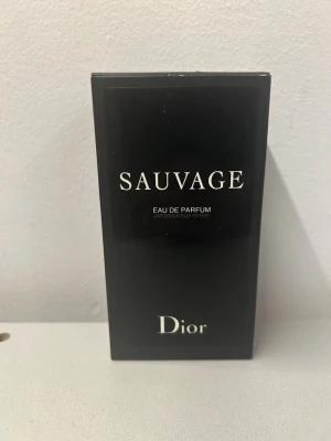 Dior Sauvage Eau de Parfum - Dior Sauvage Eau de Parfum är en lyxig herrdoft i en elegant svart förpackning med vit text. Parfymen har en modern och maskulin känsla och flaskan är påfyllningsbar, vilket gör den både snygg och praktisk. Perfekt för dig som gillar exklusiva dofter. Priset kan diskuteras 