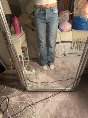 Lljusblå raka jeans - Klassiska zara jeans med rak passform och hög midja. Jeansen har fem fickor, knappgylf och är tillverkade i slitstark bomullsdenim. Perfekta för en avslappnad och tidlös look.