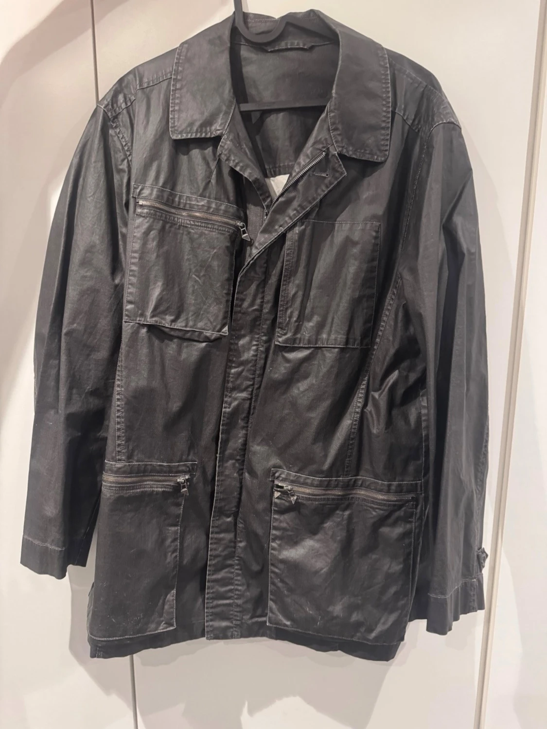 Svart regnjacka med dragkedjor