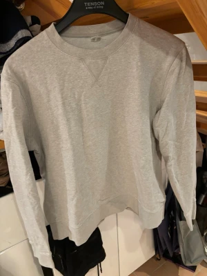 Sand sweatshirt i bomull - En sandfärgad sweatshirt med rund hals och långa ärmar. Tillverkad i mjuk bomullsmix och har ribbade muddar vid ärmslut och nederkant. Perfekt för en avslappnad och enkel stil. Från arket
