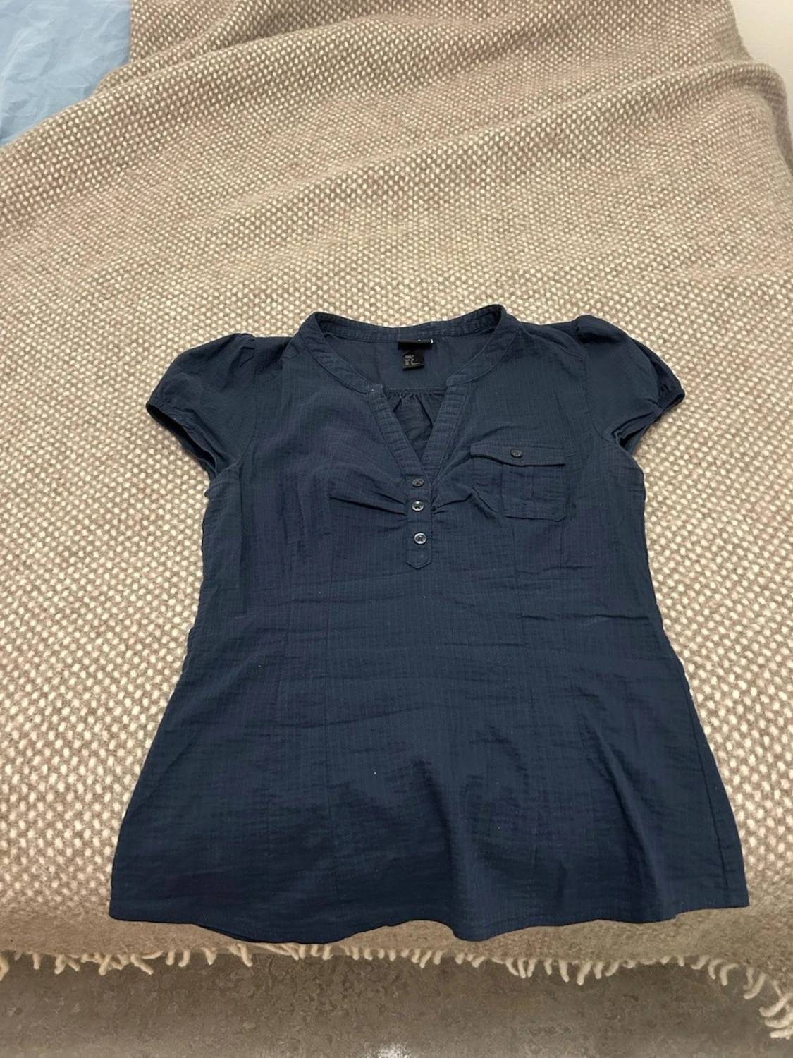 Mörkblå blus med knappdetaljer