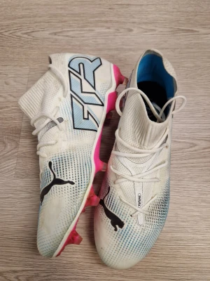 Vita Puma fotbollsskor med blå detaljer - Puma fotbolls skor st39 hadde dem i några träningar men sen slutade jag på fotboll och behöver dem inte säljer jätte billigt vill bara bli av med dem