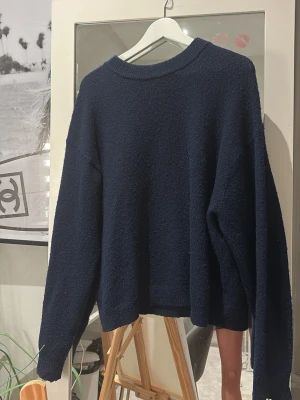 Mörkblå stickad tröja - Mysig mörkblå stickad tröja med rund halsringning och avslappnad passform. Perfekt för lager-på-lager och enkel att matcha med jeans eller kjol. Materialet känns fluffigt och ger en skön känsla. (Finns noppar då den använts som de flesta stickade tröjor får efter de används)🥰