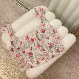 Blommig spetsig korsettopp - Supersöt korsettopp i vit spets med blommigt mönster i rött och grönt. Toppen har breda axelband, en liten rosett framtill och är croppad. Perfekt för dig som vill ha en romantisk och trendig look.