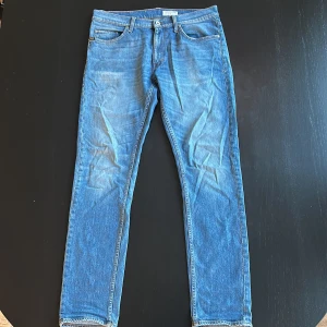 Blå jeans från Tiger of Sweden  - Snygga blå jeans från Tiger of Sweden i modellen Pistolero. Klassisk femficksdesign, raka ben och normal passform. Jeansen har en en riktigt snygg ljusare tvätt som funkar året om. Storlek 32/34 och sitter riktigt snyggt. Sparsmakat använda. 