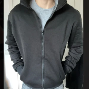 Svart Fullzip - Riktigt bekväm, varm och go full zip. Super skönt material och riktigt snygg. Perfekt nu till höstens kallare dagar. Helt ny och aldrig använd, Storlek S men passar även M!