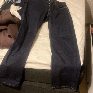 Baggy mörkblå jeans - Säljer ett par klassiska jeans i mörkblå tvätt. Byxorna har rak passform, fem fickor och knappgylf. Perfekta för dig som gillar tidlös stil och vill ha ett par jeans som funkar till allt. Jeansmaterialet är slitstarkt och håller länge. Skit snygga på. Köpte för en vecka sen!!