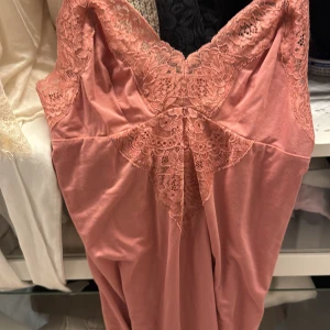 Rosa spetsklänning med v-ringning - Nattlinne/klänning från intimissimi. Köpt i Spanien, liten för sin storlek. Den är m men sitter perfekt på mig som vanlighetens vis är xs. Aldrig använd pga har en del andra och just denna kom ej till användning. 