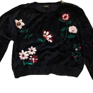 Svart sammetströja Juicy Couture - Svart långärmad tröja från Juicy Couture Black Label. Den har en dragkedja på ena axeln. Den är lite kortare än en vanligt tjocktröja.