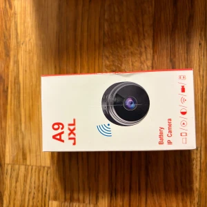 A9 JXL Battery IP Camera - Kompakt trådlös IP-kamera med batteridrift, perfekt för övervakning i hemmet eller kontoret. Enkel installation, stöd för WiFi och rörelsedetektering. Produkten är ny i förpackning utan  skador eller slitage.