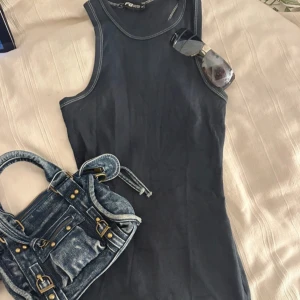 Blå ribbad kortklänning - Supersnygg svart ribbad kortklänning. Perfekt för dig som gillar en enkel men edgy stil. Materialet är mjukt och stretchigt för en bekväm passform.