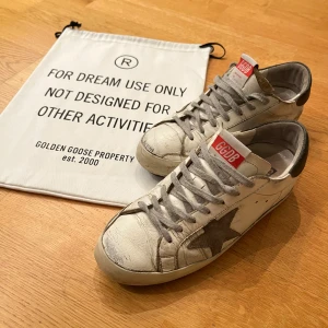 Golden Goose Superstar skor - Säljer ett par riktigt snygga fast slitna skor från golden goose. Sulan på högerskon är limmad men det har hållit rätt så bra, annars är dom i helt okej skick ändå. Skorna är äkta men de följer inte med någon skolåda. Skriv om ni har fler frågor eller funderingar🔥